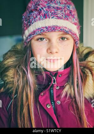 Portrait eines Mädchens mit lila Haaren streifen tragen lila Winter Mantel und Hut Stockfoto