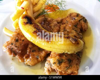 Degenfisch mit Pommes frites, gekrönt mit einem gebratenen Bananen. Ein typisches Gericht aus Madeira, Portugal Stockfoto