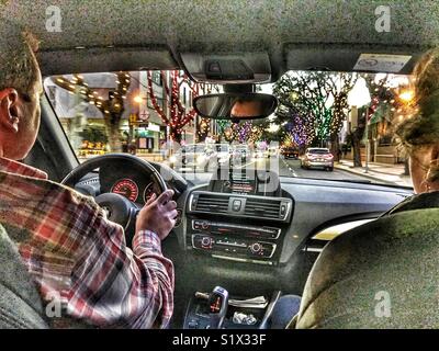 Blick durch Auto Windschutzscheibe, über die Straße vom Rücksitz mit Weihnachtsbeleuchtung in der Dämmerung, Funchal, Madeira, Portugal Stockfoto