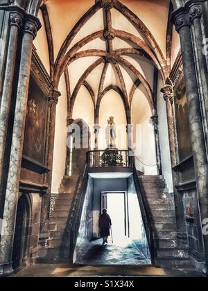 Silhouette einer alten Dame mit einem Stock verlassen die Kathedrale Se durch eine gewölbte Seite Eingang, Funchal, Madeira, Portugal Stockfoto