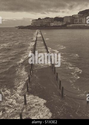 Wellen brechen über die Marine Lake Causeway in Weston-super-Mare, Großbritannien Stockfoto