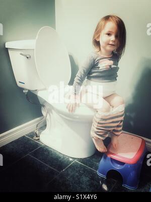 Kleinkind Mädchen auf der Toilette sitzen im Bad mit Stolz Ausdruck auf dem Gesicht Stockfoto