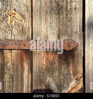 Alten rostigen Scharniere aus Schmiedeeisen an eine Tür montiert. Stockfoto