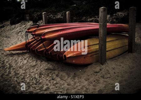 Stapel von Kajaks am Strand Stockfoto