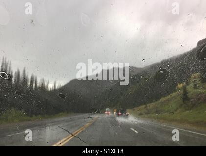 Gelangt der Regen während der Fahrt durch heftiger Platzregen auf den Berg Straße in Colorado Stockfoto