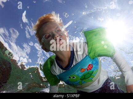 Ein Junge bläst Luft blasen unter Wasser beim schnorcheln in den U.S. Virgin Islands. Stockfoto