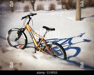 Ein Fahrradverleih steht auf seinen eigenen im kumulierten Schnee. Stockfoto