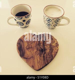 2 Tassen Kaffee und ein Herz geformt Schneidebrett für Kaffeeliebhaber Stockfoto