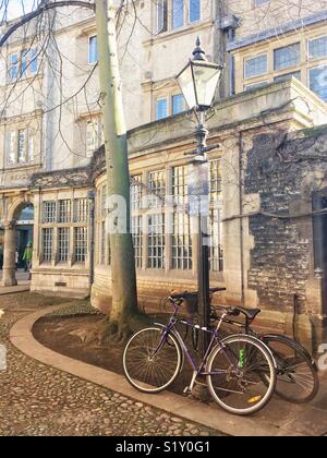 Fahrrad gegen eine altmodische Strassenlaterne außerhalb des Trinity College, Cambridge Stockfoto