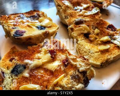 Hot Cross Buns, geröstet, mit reichlich Butter Stockfoto