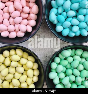 Nahaufnahme von vier Schalen mit Zucker überzogen Schokolade Mini - Eier, nach Farben getrennt. Stockfoto