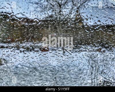 Gefrierender Regen auf dem Fenster eines Hauses. Eisregen ist Niederschlag, fällt als unterkühlte Wassertröpfchen bis es Streiks eine kalte Oberfläche, wenn es fast sofort gefriert Stockfoto