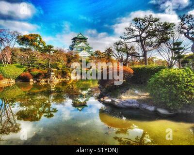 Burg von Osaka reflektiert in einem Pool im Frühjahr Stockfoto