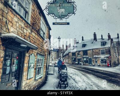 De, Wetter, Sherbourne, Dorset. Drücken einen Buggy durch den Schnee in Sherborne als so genannte Mini Tier aus dem Osten eine andere eisige Blast im Süden Westen bringt. Stockfoto