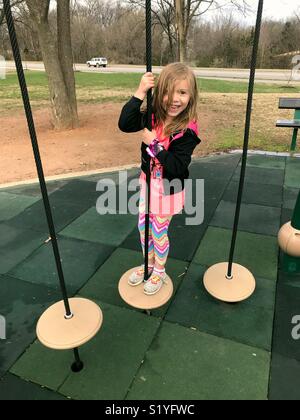 Ein kleines Mädchen spielt auf einem Spielplatz in Bentonville, Arkansas. Stockfoto