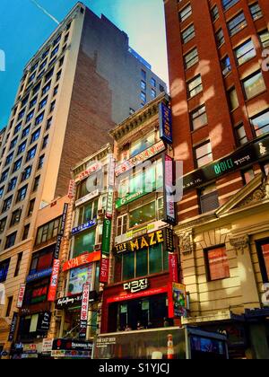 Bunte Fassaden mit mehrsprachigen Beschilderungen in Koreatown, W. 32nd St., New York City, USA Stockfoto