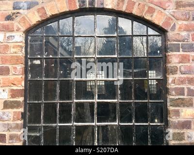 Alte Stahl Fenster, gewölbter Kopf, Crittal Stil, in einem industriellen Workshop Stockfoto
