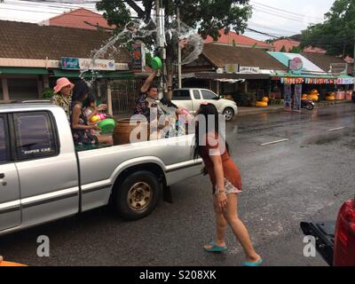 Songkran Festival 2018, Wasser, Frau werfen Wasser bei Passanten in Pick up. Songkran Tag, Udon Thani, Isaan, Thailand Stockfoto