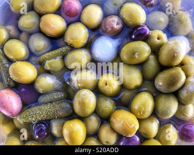 Gemischte grüne Oliven, schwarze Oliven, Gurken, eingelegte Zwiebeln, am Donnerstag Markt in Javea, Spanien Stockfoto