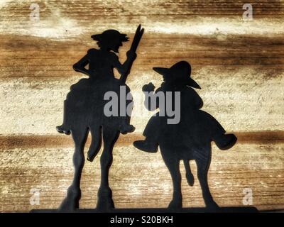 Don Quichotte und Sancho Pansa, Silhouette einer Metall Bücherstütze legte flach auf Holz- Hintergrund Stockfoto