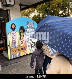 Junge wartet geduldig auf seine biegen Sie an einen Ausschnitt des Schloss Himeji, Japan. Stockfoto