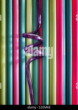 Mehrfarbige Halme aus Kunststoff mit einer violetten Spirale Stroh in der Mitte Stockfoto