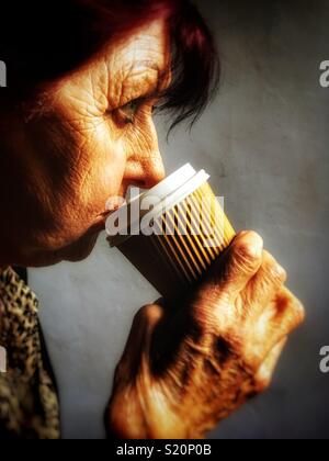 Frau trinkt eine Tasse Kaffee zum Mitnehmen Stockfoto