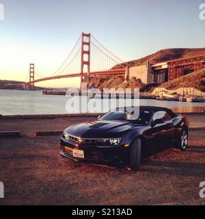 Chevrolet Camaro SS Convertible vor der Golden Gate Bridge Ende November, wenn die Sonne aufgeht Stockfoto