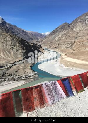 Gebetsfahnen über Sangam, die Sitzung des Indus und Zanskar Flüsse in Ladakh, Indien Stockfoto