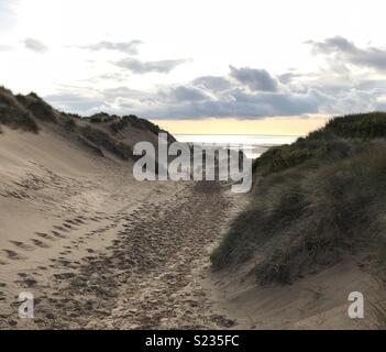 Sandigen Weg durch die Dünen zum Strand bei Sonnenuntergang. Stockfoto