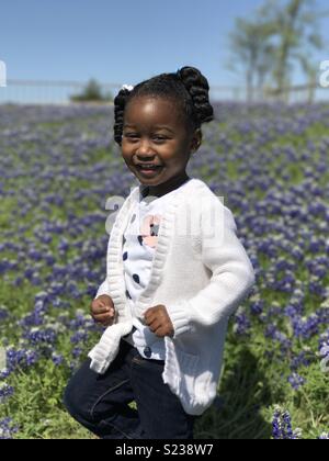 Enkelin in bluebonnet Feld Stockfoto