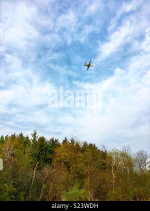 Flugzeug gegen den blauen Himmel über Wald fliegen Stockfoto