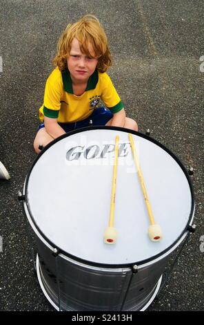 Kleine Junge saß Wartezeiten vor große Trommeln, Drumsticks bereit Stockfoto