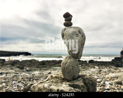 Naturstein balancing Skulptur am Strand mit Wellen. Stockfoto