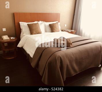 Brown's Frau Handtasche auf Hotel Bed Stockfoto