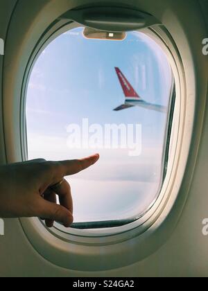 Einer Frau Finger in Edinburgh, als ein Flug mit Norwegian Airlines nähert sich der Stadt. Stockfoto