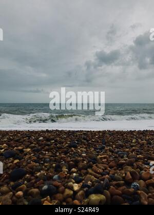 Meer stürzt gegen Steine am Strand Stockfoto