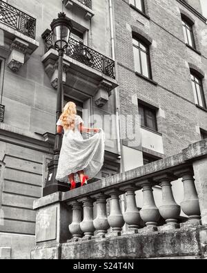 Blonde Modell in weissem Kleid und rote Schuhe in einem Pariser backstreet Posing Stockfoto