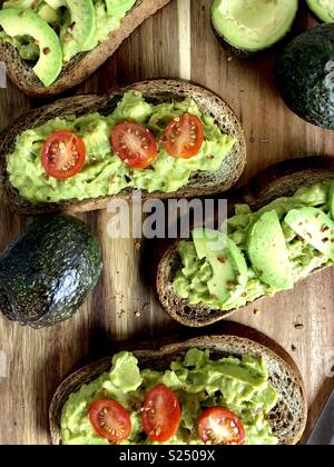 Blick von oben auf die Avocado Toast auf einem Holz Schneidebrett Stockfoto