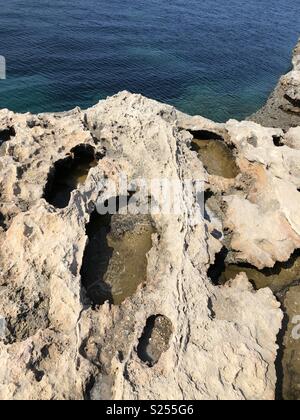 Rock mit Bohrungen und Meer auf Ibiza in Spanien Stockfoto