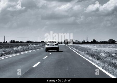 Ein weißes suv auf einer Geraden einsame Landstraße Stockfoto