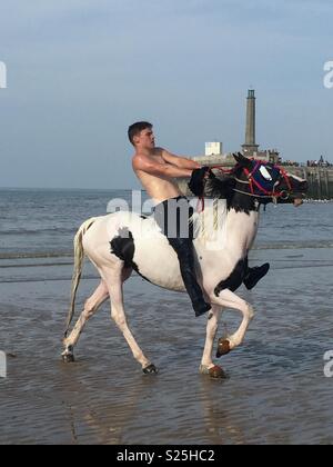 Pferde Abkühlung im Meer bei Margate Main Sands um Kent Küste mit Reisenden und Fallen ride Stockfoto