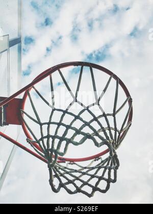 Auf der Suche auf einen Basketballkorb von der Seite mit einem bewölkten Himmel im Hintergrund Stockfoto