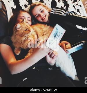 Zwei jugendliche Mädchen eine selfie mit orange Pet cat Stockfoto