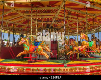 Traditionelle Merry-go-round, Karussell mit bunten Pferde, Sherborne Castle Country Fair, Sherbourne, Dorset, England Stockfoto