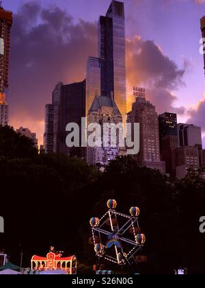 Ein dramatischer Sonnenuntergang über Midtown Manhattan und Viktorianischen Gärten im Central Park, New York City, USA Stockfoto