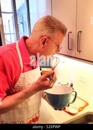 Bunt gekleideter älterer Mann kochen in einer Wohnung Küche, USA Stockfoto