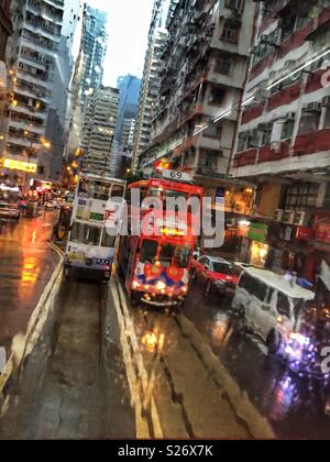 Straßenbahnen auf Johnston Road, Wan Chai, Hong Kong Island, durch die feuchten Fenster einer Straßenbahn gesehen Stockfoto