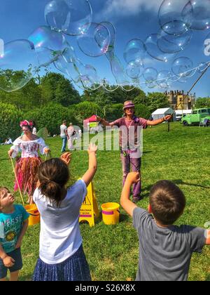 Unterhaltsame Kinder in Sherborne Castle Country Fair mit riesigen Seifenblasen, Sherbourne, Dorset, England Stockfoto