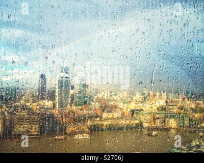 Regen auf dem Fenster der Shard, London, UK, über die Themse in Richtung Fenchurch Street und über die Stadt. Ein Regenbogen der Himmel leuchtet wie die Sonne durch Brüche, beleuchtet die Stadt unten. Stockfoto